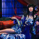 Ko Shibasaki is dressed in full-costume for the xxxHolic movie, sitting on a sofa and smoking a pipe.